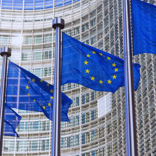 eu-ai-act European Union Flags Fluttering in Front of a Glass Modern Office Building